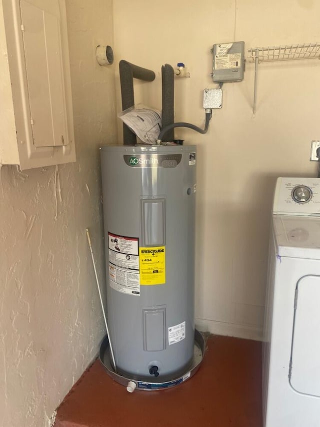 utility room with water heater, washer / dryer, and electric panel