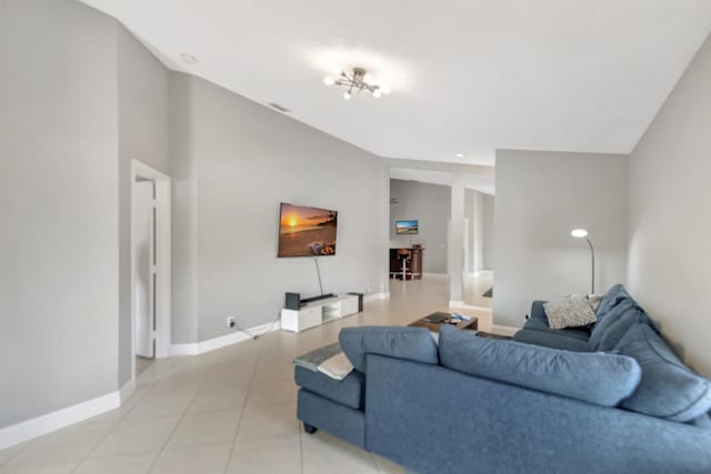 tiled living room featuring a notable chandelier