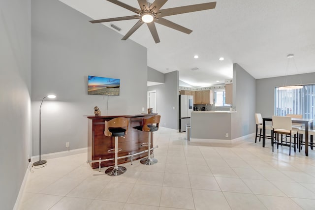 interior space featuring light tile patterned floors, white refrigerator, ceiling fan, and lofted ceiling