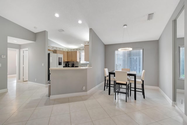 tiled dining area with a textured ceiling, an inviting chandelier, and vaulted ceiling