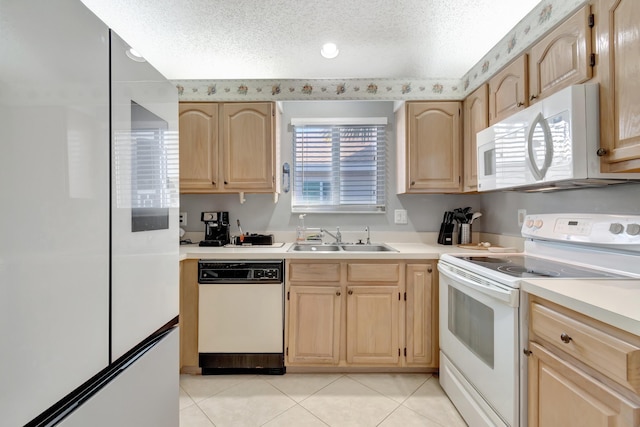 kitchen featuring a textured ceiling, light brown cabinets, white appliances, and sink