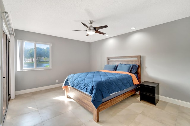 bedroom with ceiling fan and a textured ceiling