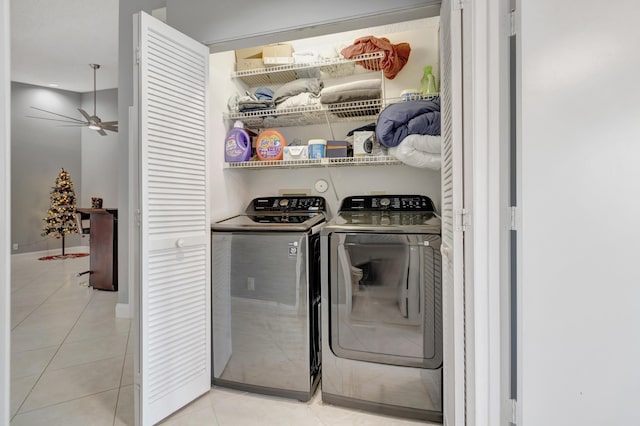 clothes washing area with ceiling fan, washing machine and dryer, and light tile patterned floors