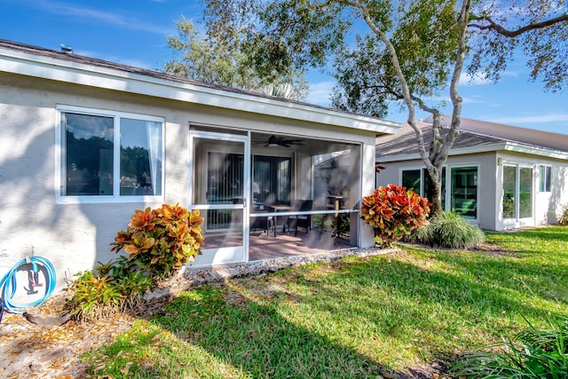 rear view of house with a sunroom and a yard