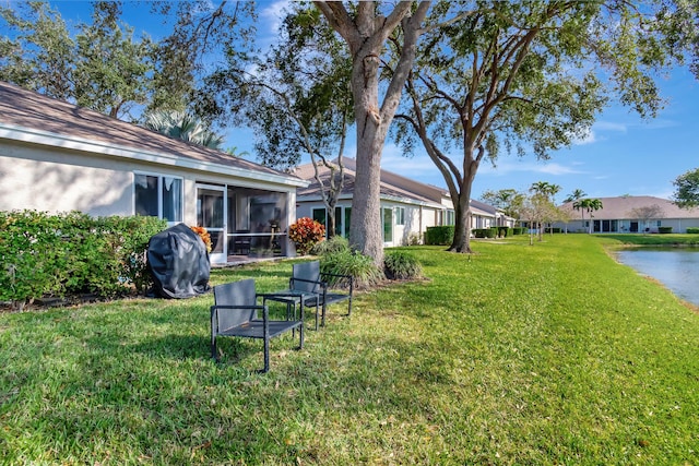 view of yard featuring a water view and a sunroom