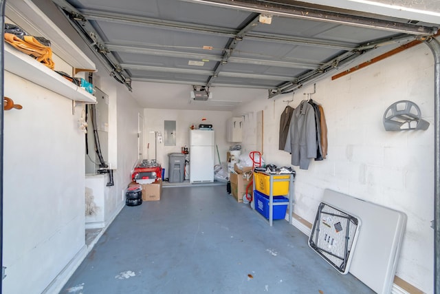 garage with white refrigerator, electric panel, and a garage door opener