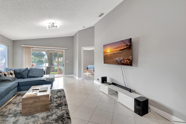 living room with light tile patterned flooring, lofted ceiling, and a textured ceiling