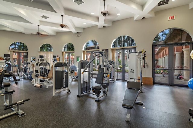 exercise room with a high ceiling, ceiling fan, and a healthy amount of sunlight