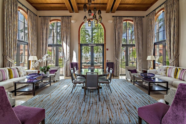 sunroom with a chandelier, beam ceiling, french doors, and wood ceiling