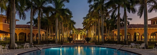 pool at dusk with a patio area