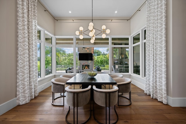 dining space with a fireplace, a chandelier, and dark hardwood / wood-style floors