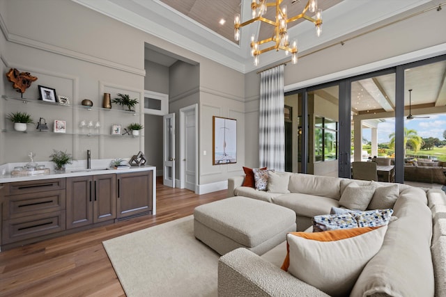 living room with a high ceiling, ceiling fan with notable chandelier, and wood-type flooring