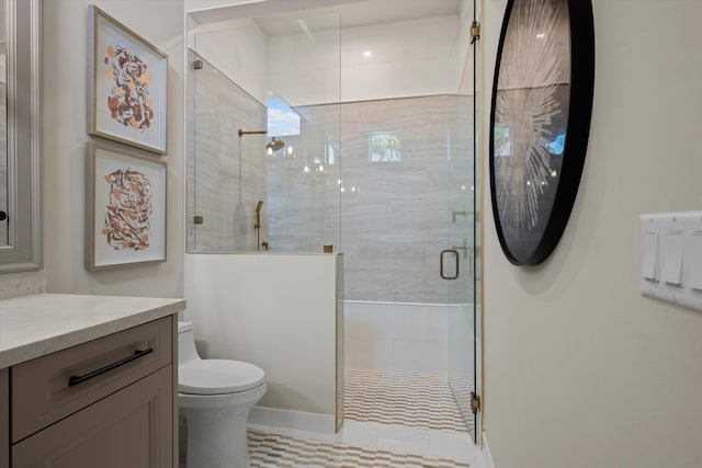 bathroom with tile patterned floors, vanity, toilet, and a shower with door