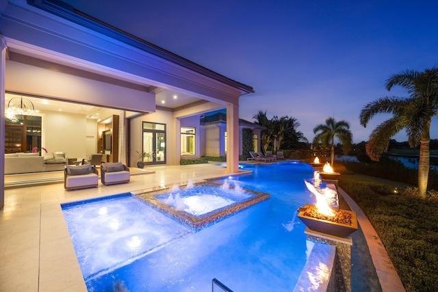 pool at dusk featuring pool water feature, a patio area, an in ground hot tub, and an outdoor fire pit