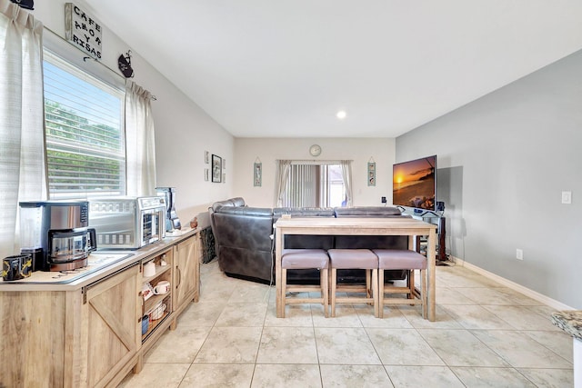 interior space with light tile patterned flooring, plenty of natural light, and light brown cabinets