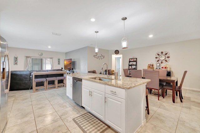 kitchen featuring appliances with stainless steel finishes, an island with sink, white cabinets, pendant lighting, and sink