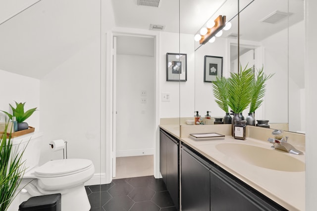 bathroom featuring toilet, vanity, and tile patterned floors