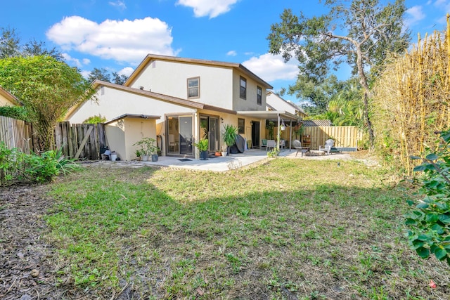 rear view of house with a patio area and a yard