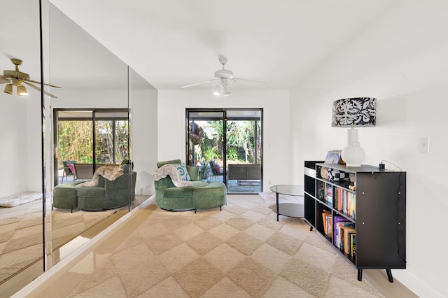 sitting room with light colored carpet, ceiling fan, and a healthy amount of sunlight