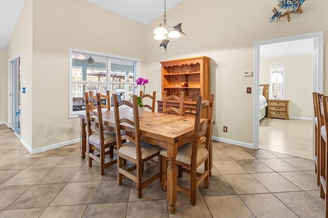 tiled dining area with a chandelier and lofted ceiling