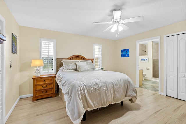 bedroom featuring ceiling fan, a closet, ensuite bathroom, and light hardwood / wood-style floors