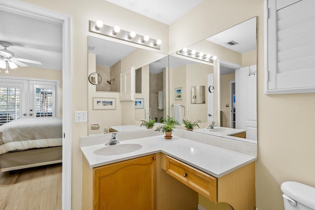 bathroom with a textured ceiling, vanity, ceiling fan, hardwood / wood-style flooring, and toilet