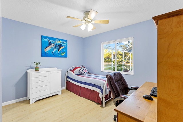 bedroom with ceiling fan, light hardwood / wood-style flooring, and a textured ceiling