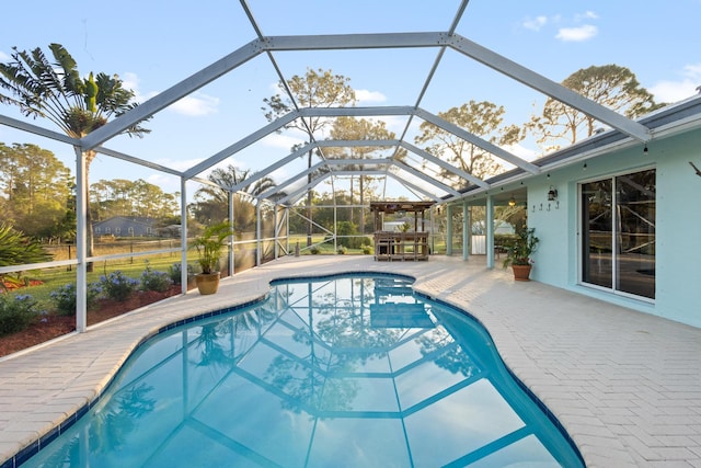 view of swimming pool with a patio area and a lanai