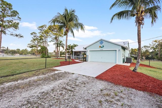 view of front of house featuring a front yard, central AC, and a garage