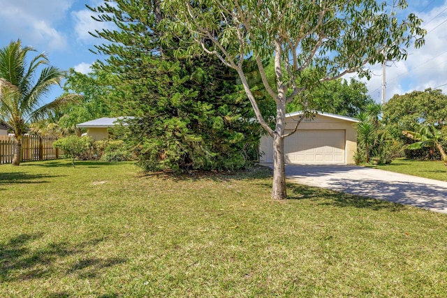 view of front of property featuring a garage, driveway, a front lawn, and fence