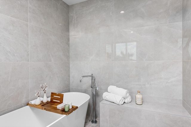 bathroom featuring tile walls and a bath