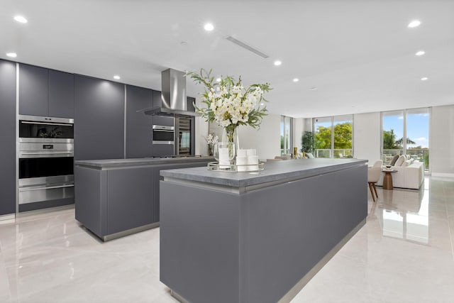 kitchen featuring floor to ceiling windows, double oven, island range hood, and a kitchen island