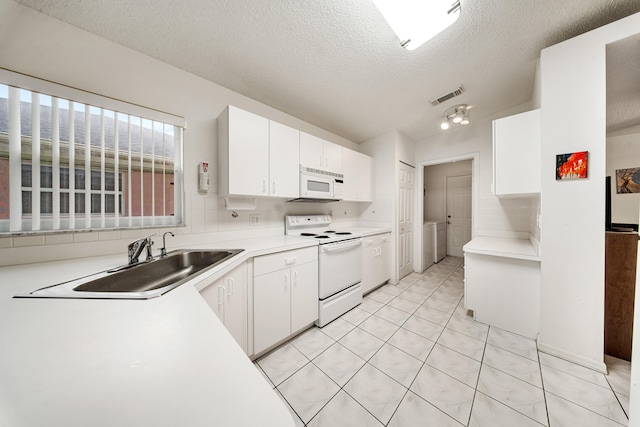 kitchen with a textured ceiling, sink, white cabinets, and white appliances