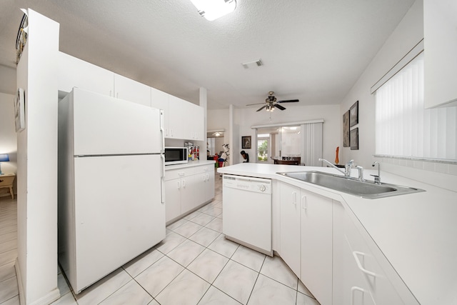 kitchen with ceiling fan, sink, kitchen peninsula, white appliances, and white cabinets