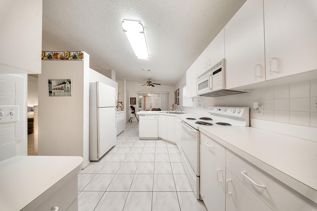 kitchen with white appliances, white cabinets, sink, ceiling fan, and kitchen peninsula