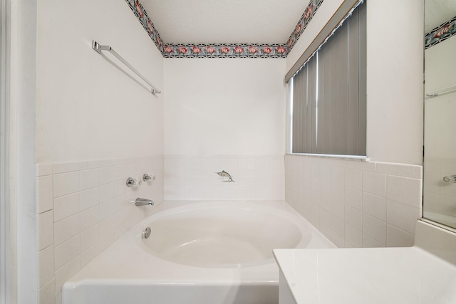 bathroom with a tub and vanity