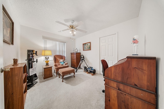 carpeted office space with ceiling fan and a textured ceiling