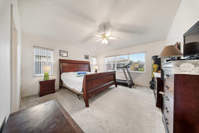 carpeted bedroom with ceiling fan and a textured ceiling