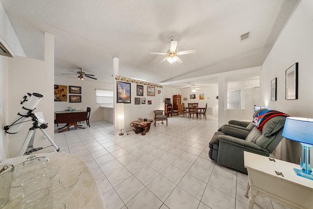 living room featuring ceiling fan, light tile patterned flooring, and lofted ceiling