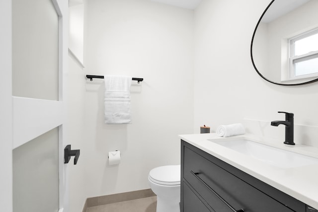 bathroom with tile patterned flooring, vanity, and toilet