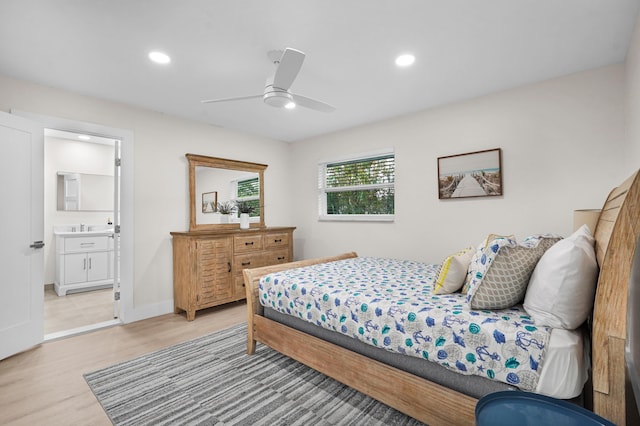 bedroom featuring connected bathroom, light hardwood / wood-style floors, and ceiling fan