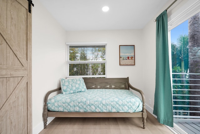 bedroom with hardwood / wood-style flooring and a barn door