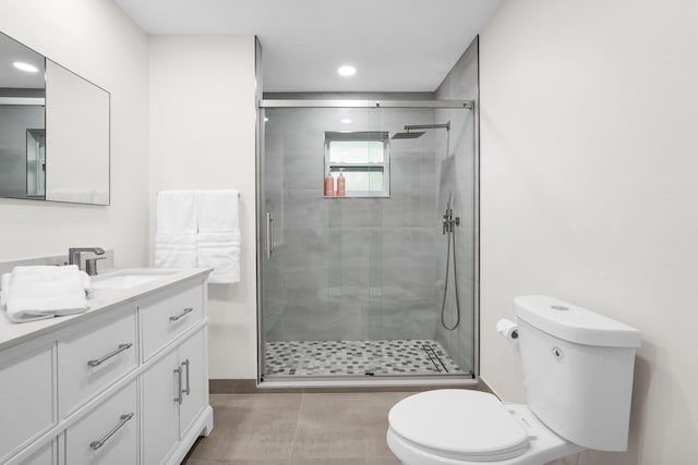 bathroom with vanity, a shower with shower door, and toilet