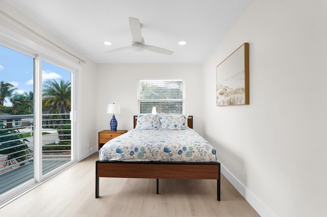 bedroom featuring ceiling fan, access to exterior, light hardwood / wood-style flooring, and multiple windows