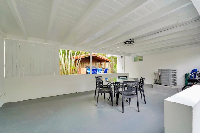 dining area with beam ceiling and concrete floors