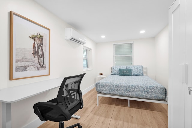 bedroom with light hardwood / wood-style flooring and a wall mounted AC