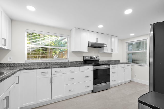 kitchen with white cabinets, refrigerator, stainless steel electric range oven, and dark stone counters