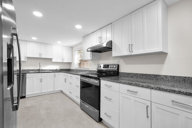 kitchen with sink, white cabinetry, stainless steel appliances, and dark stone counters