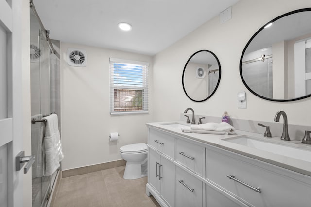 bathroom featuring tile patterned floors, vanity, a shower with shower door, and toilet