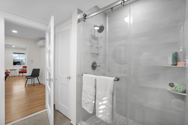 bathroom featuring hardwood / wood-style floors, an AC wall unit, and walk in shower